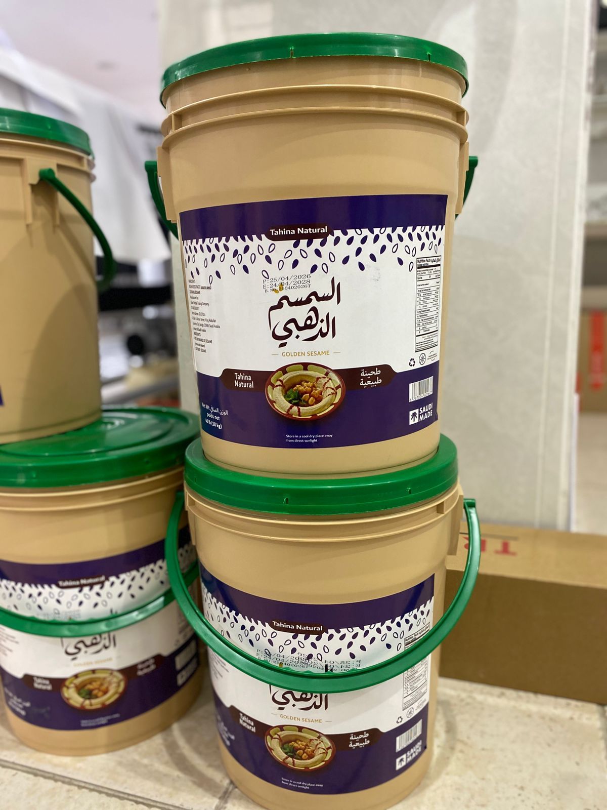 دلاء طحينة مكدسة بملصقات مطبوعة ملفوفة حول كل دلو
